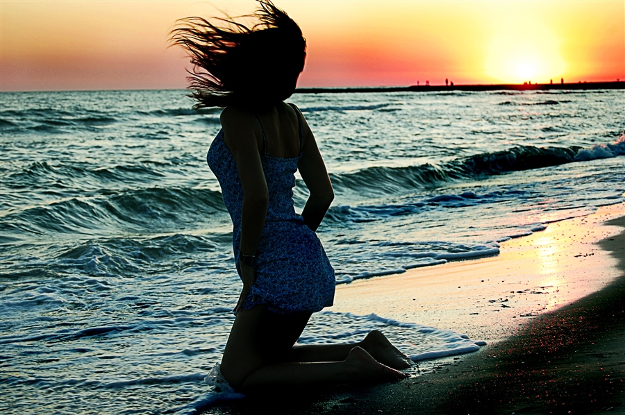 Девушка смотрит на море со спины фото